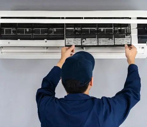 A repairman working on an AC unit