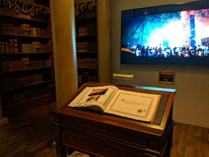 Book on display while a video plays on a tv in the background
